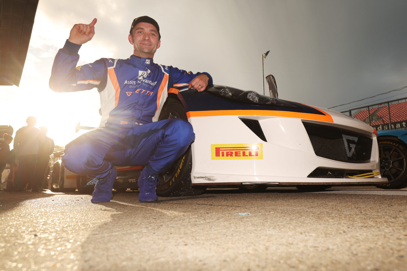 racing driver posing with his race car